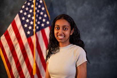 Picture of Anika in front of american flag.