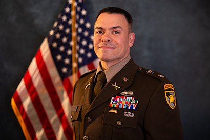 Image of LTC Mahoney in front of US flag.